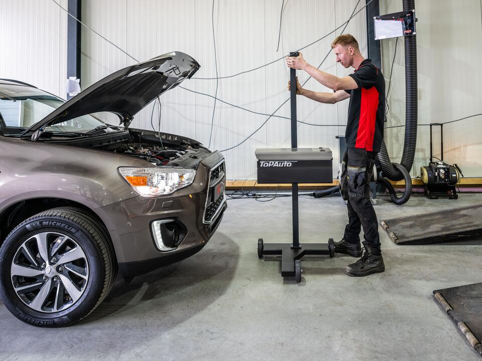Monteur van FZ Auto's stelt de koplampen af met de koplamptester in Peize