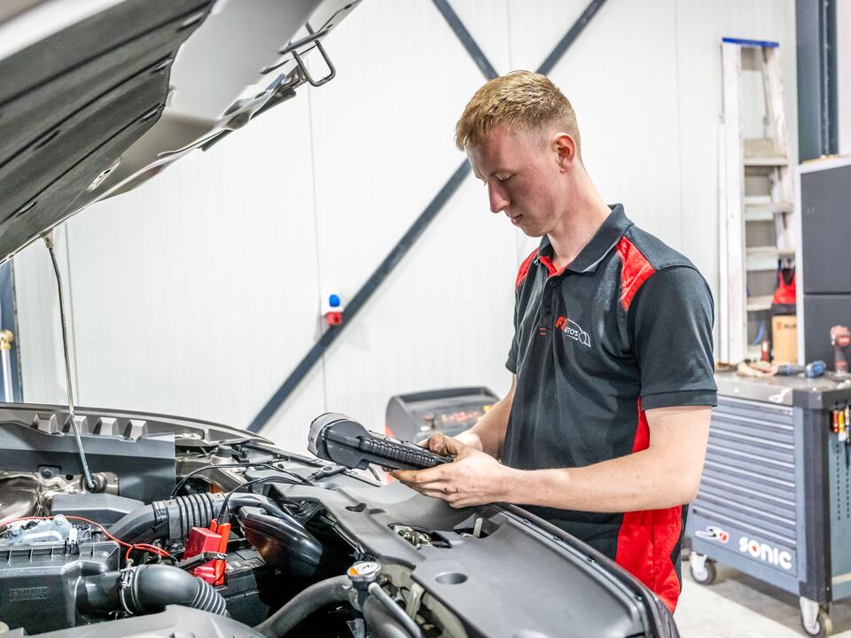 Monteur van FZ Auto's leest een tester af bij de geopende motorkap in Peize