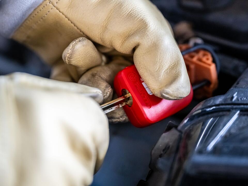 Monteur van FZ Auto's koppelt met isolerende handschoenen de hoogspanning veilig los in Roden