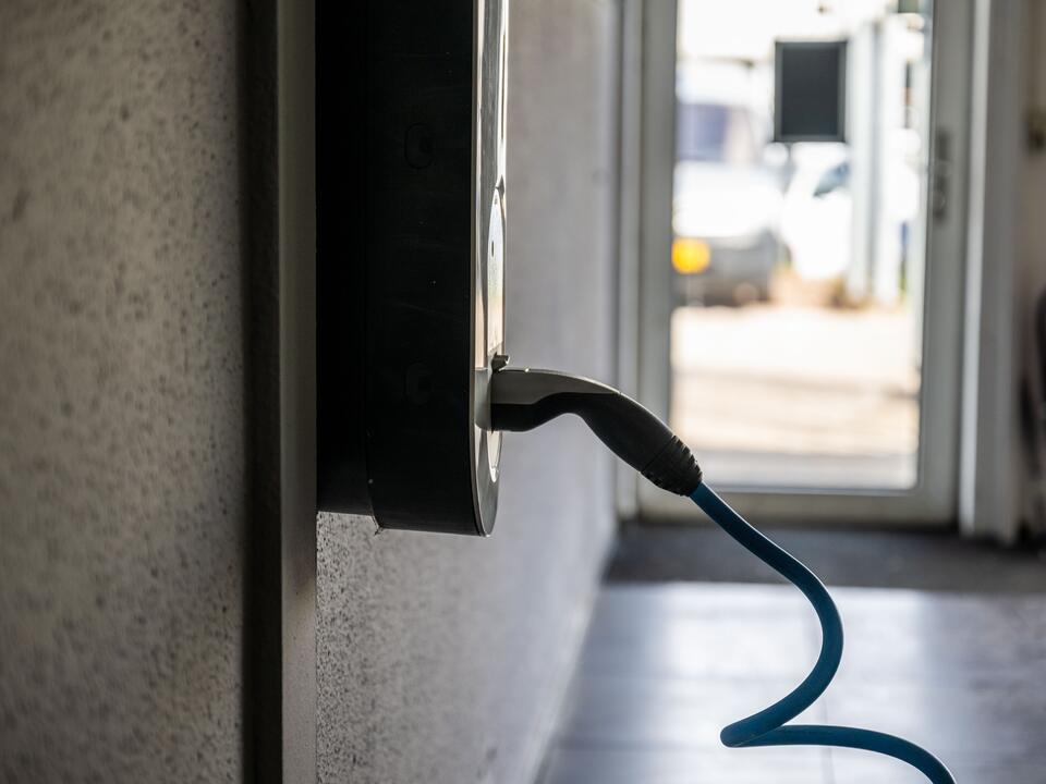 Laadkabel aan de wand in de werkplaats van FZ Auto's in Roden